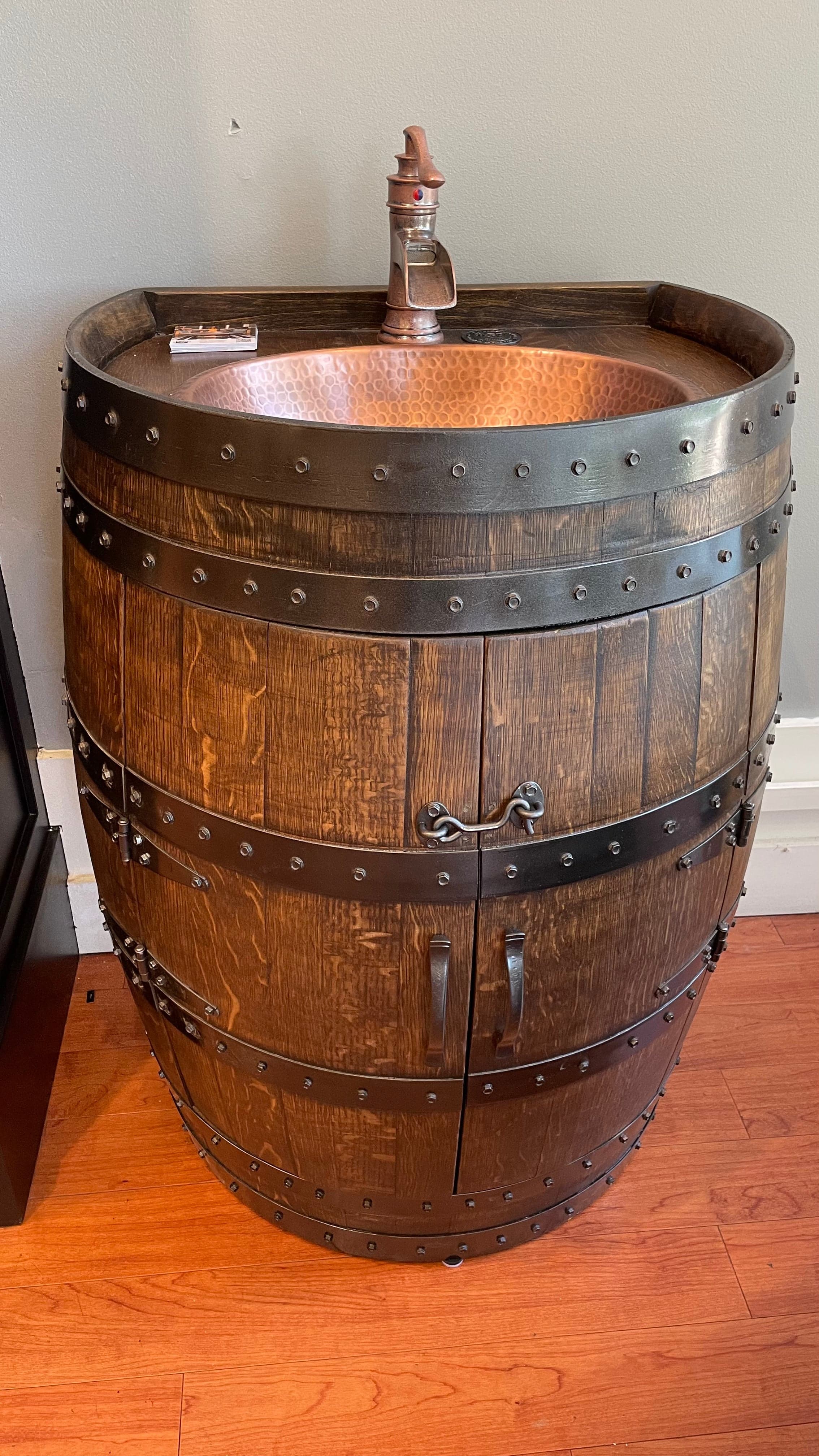 Oak barrel vanity with a hammered copper sink and faucet