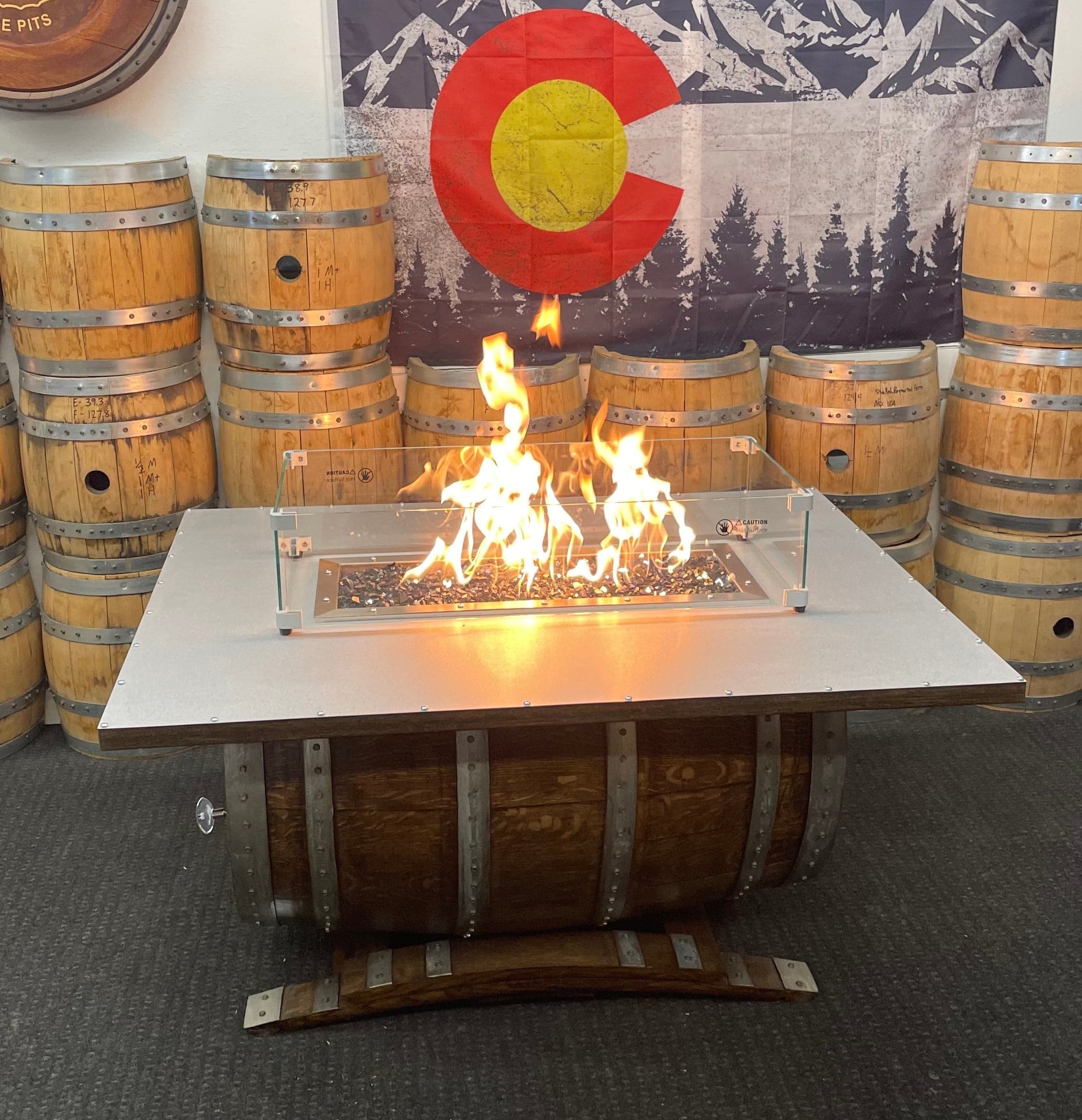 Barrel on its side with a rectangular tabletop, glass wind guard and flame